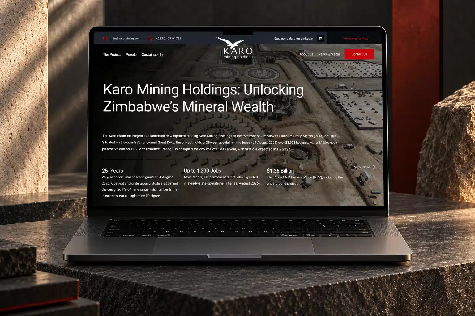 Karo Mining homepage on a space-black MacBook Pro surrounded by dark stone and red steel
