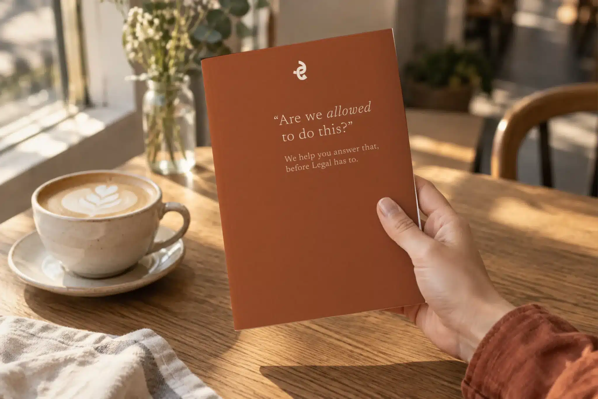 Grounded Compliance booklet held open in a café