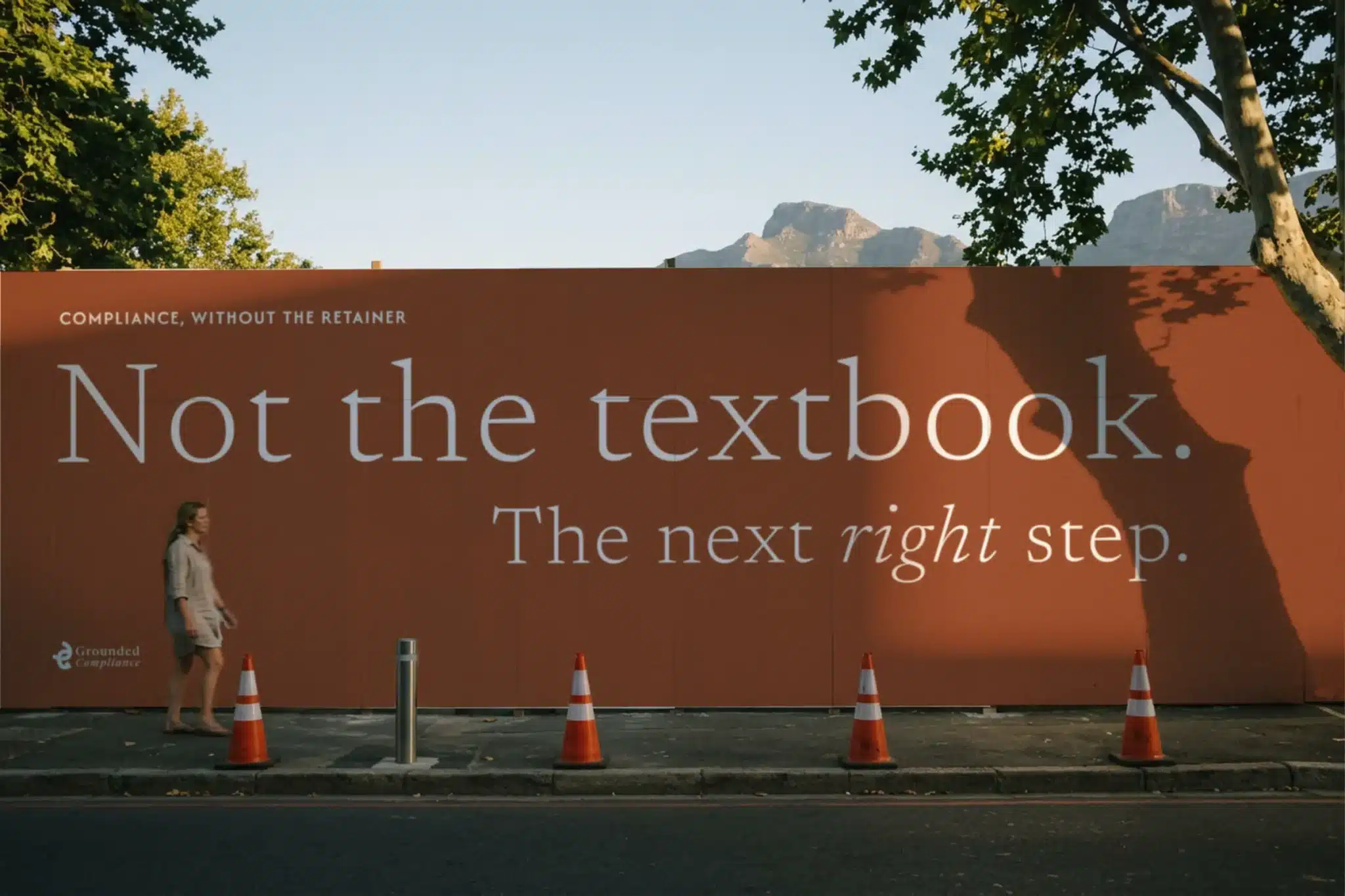 Grounded Compliance hoarding on a Cape Town street with the line Not the textbook. The next right step.